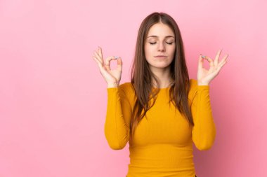 Zen pozunda pembe arka planda izole edilmiş beyaz bir kadın.