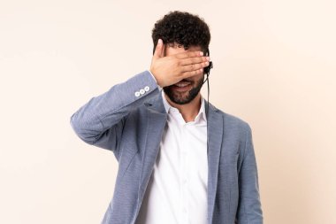 Tele pazarlamacı Faslı bir adam bej arka planda gözlerden uzak bir kulaklıkla çalışıyor. Bir şey görmek istemiyorum.