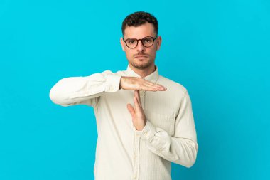 Beyaz tenli yakışıklı adam mavi arka planda izole edilmiş.