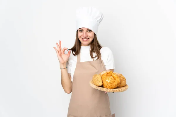 身穿厨师制服的年轻妇女被隔离在白色背景下 手指头上有一个好的标志 — 图库照片