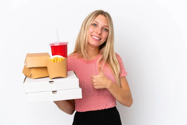 Junge Kaukasische Frau Hält Fettes Essen Isoliert Auf Blauem Hintergrund — Stockfoto