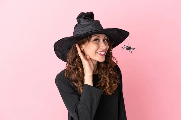 Joven Mujer Caucásica Celebrando Halloween Aislada Sobre Fondo Rosa Escuchando —  Fotos de Stock