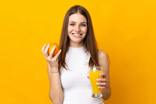 Junge Kaukasische Frau Hält Eine Orange Auf Orangefarbenem Hintergrund — Stockfoto