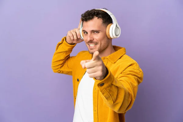 Joven Hombre Guapo Caucásico Aislado Sobre Fondo Púrpura Escuchando Música — Foto de Stock