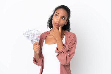 Genç Afrikalı Amerikalı kadın, beyaz arka planda izole edilmiş bir sürü para alıyor. Şüpheleri var.