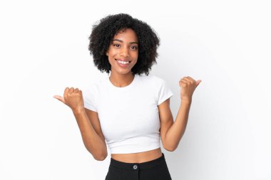 Beyaz arka planda izole edilmiş genç Afrikalı Amerikalı kadın. Baş parmakları havada ve gülümsüyor.