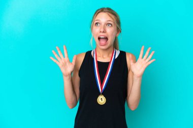 Mavi arka planda madalyalı beyaz bir kadın. Yüzünde sürpriz bir ifade var.