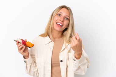 Beyaz arka planda saşimi tutan beyaz bir kadın geliyor.