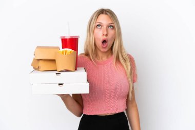 Mavi arka planda yağlı yiyecekler taşıyan beyaz bir kadın yukarı bakıyor ve şaşırmış bir ifadeyle