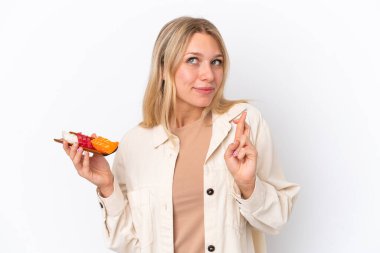 Beyaz arka planda saşimi tutan beyaz tenli genç kadın şans diliyor.