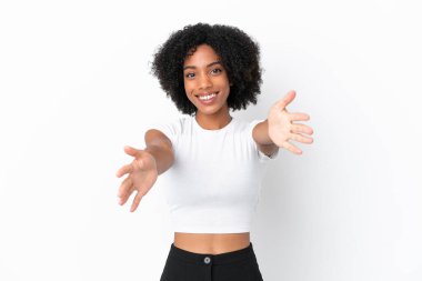 Beyaz arka planda izole edilmiş genç Afrikalı Amerikalı kadın sunar ve davet eder.