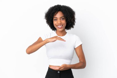 Beyaz arka planda izole edilmiş genç bir Afro-Amerikalı kadın bir ilan vermek için avucunun içinde hayali bir şey tutuyor.