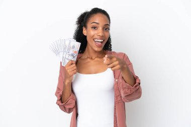 Genç Afrikalı Amerikalı bir kadın beyaz arka planda izole edilmiş bir sürü para alıyor şaşırmış ve ön tarafı işaret ediyor.