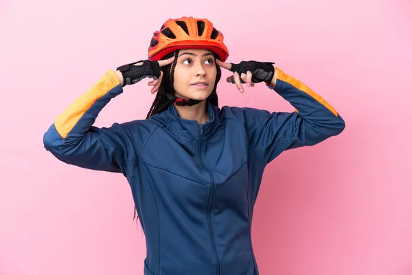 Tini Kerékpáros Lány Elszigetelt Rózsaszín Háttérrel Amelynek Kétségei Gondolkodás — Stock Fotó