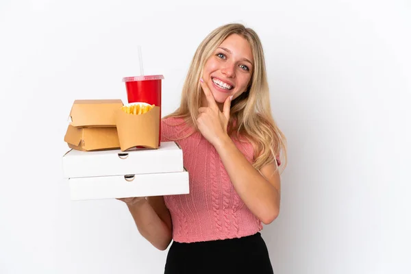 Junge Kaukasische Frau Hält Fettes Essen Isoliert Auf Blauem Hintergrund — Stockfoto