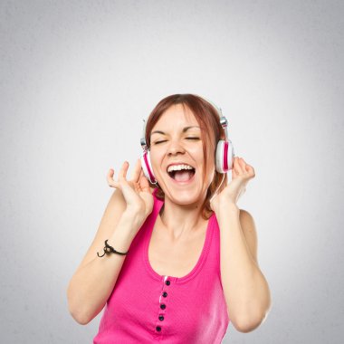genç kız gri arka plan üzerinde müzik dinleme 