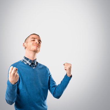 genç adam kazanan izole gri arka plan üzerinde 