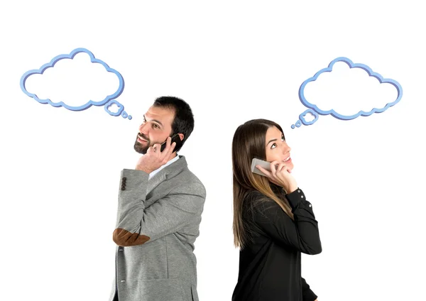 Couple talking to mobile over isolated background. — Stock Photo, Image