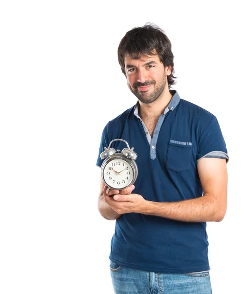 Man holding a clock over white background — Stock Photo, Image