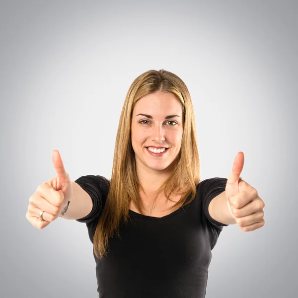 Blonde girl making Ok sign over white background — Stock Photo, Image