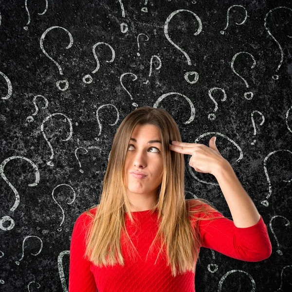 Young girl making suicide gesture over black background — Stock Photo, Image