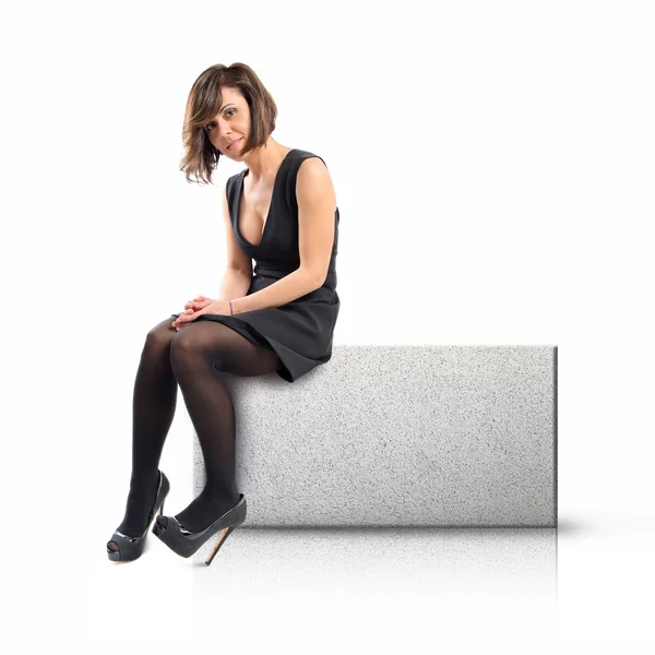 Woman sitting on rectangular placard of rough texture — Stock Photo, Image