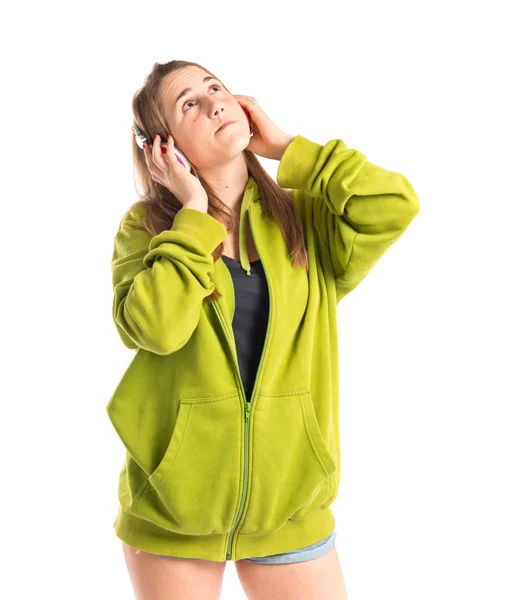 Chica joven escuchando música sobre fondo blanco —  Fotos de Stock