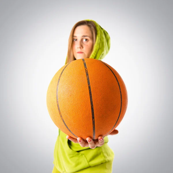 Menina loira jogando basquete sobre fundo cinza — Fotografia de Stock