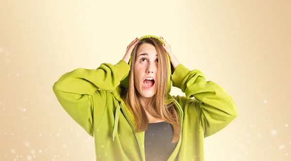 Chica joven haciendo gesto sorpresa sobre fondo ocre — Foto de Stock