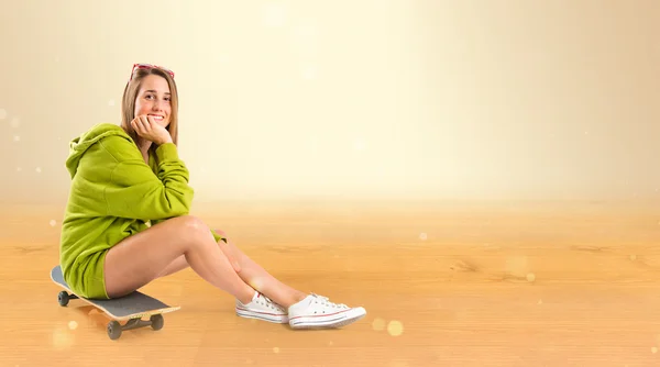 Bella ragazza che indossa stile urbano ocra skateboard — Foto Stock