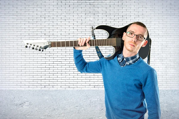Mladý muž s kytarou na podklad s texturou — Stock fotografie
