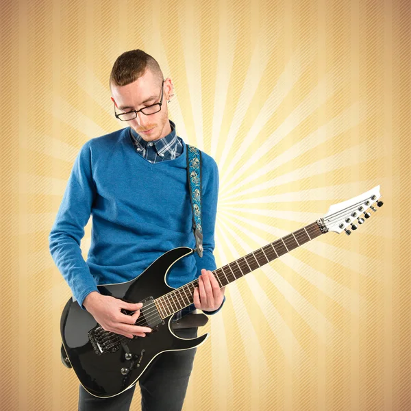Young man playing guitar over pop background — Stock Photo, Image