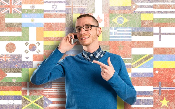 Men talking to mobile over flags background. — Stock Photo, Image