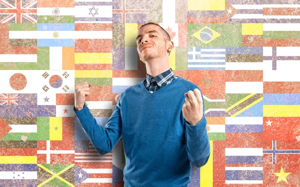 Young man winner over flags background — Stock Photo, Image