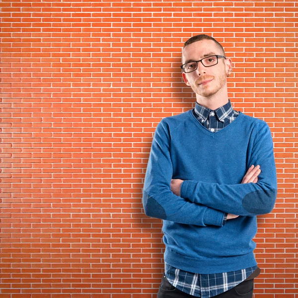 Ruiva homem com braços cruzados sobre tijolos fundo — Fotografia de Stock