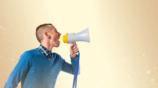 Redhead man shouting by megaphone over ocher background — Stock Photo, Image