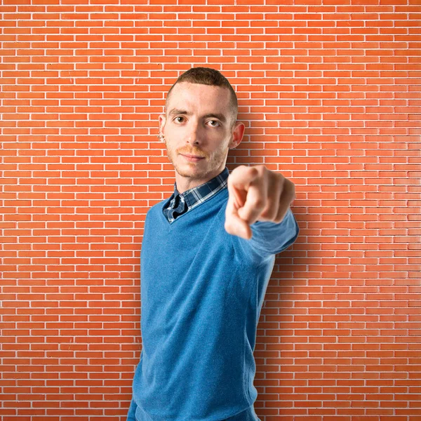 Young man pointing over isolated textured background — Stock Photo, Image