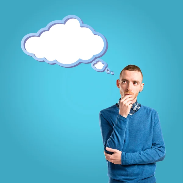 Young man thinking over blue background — Stock Photo, Image