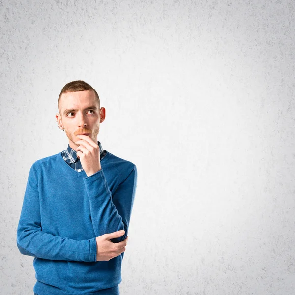 Jeune homme réfléchissant sur fond gris — Photo