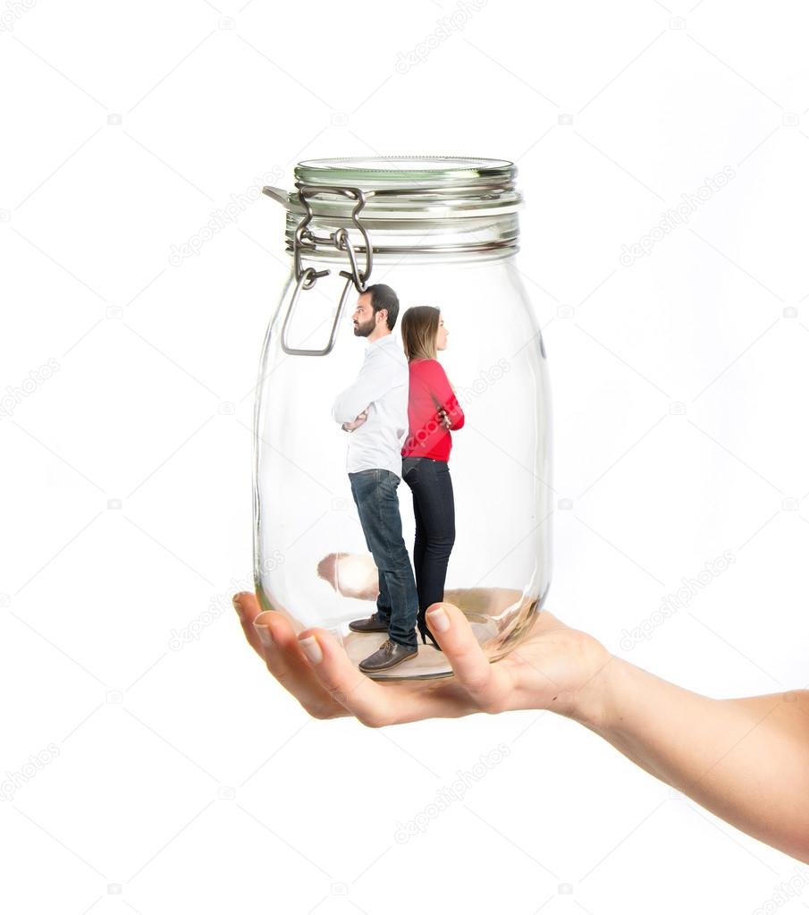 Enclosed couple inside jar glass over white background 