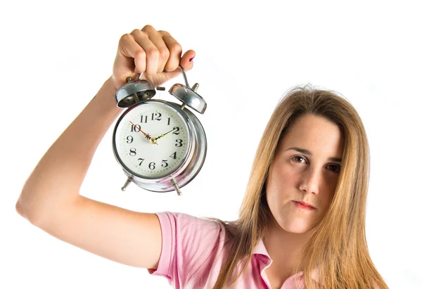 Ragazza seria che tiene un orologio su sfondo bianco — Foto Stock