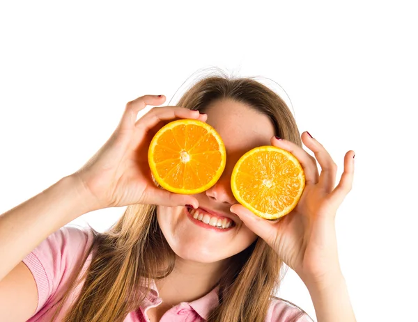 Mädchen mit Orangen in den Augen vor weißem Hintergrund — Stockfoto