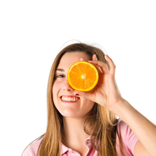 Молодая девушка играет с оранжевым на белом фоне — стоковое фото