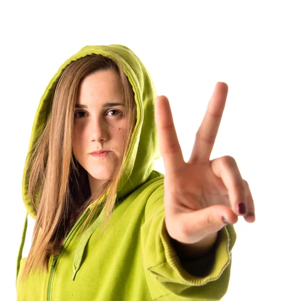 Menina fazendo gesto de vitória sobre fundo branco — Fotografia de Stock