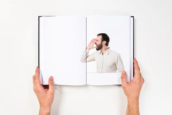 Young man screaming printed on book — Stock Photo, Image