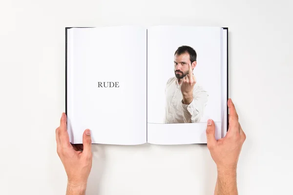 Jeune homme faisant le signe de corne imprimé sur le livre — Photo