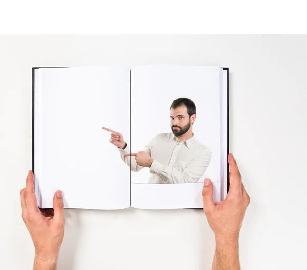 Jonge man naar zijn recht afgedrukt op boek — Stockfoto