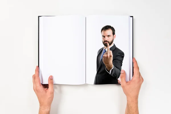 Giovane uomo d'affari che fa il segno del corno stampato sul libro — Foto Stock