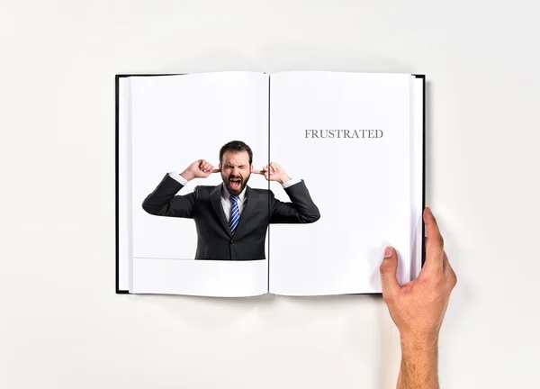 Hombre de negocios cubriendo sus oídos impresos en libro —  Fotos de Stock