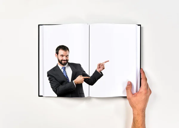 Uomo d'affari che indica il lato stampato sul libro — Foto Stock